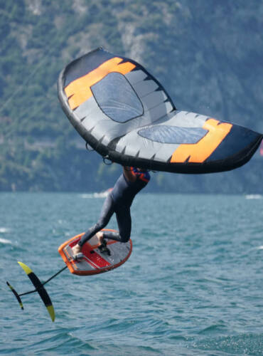A male using an inflatable wing with a board on the lake Garda in Italy